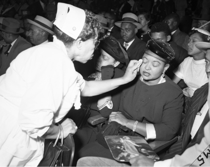 Black and white photo of a woman wiping tears from Mamie's eyes